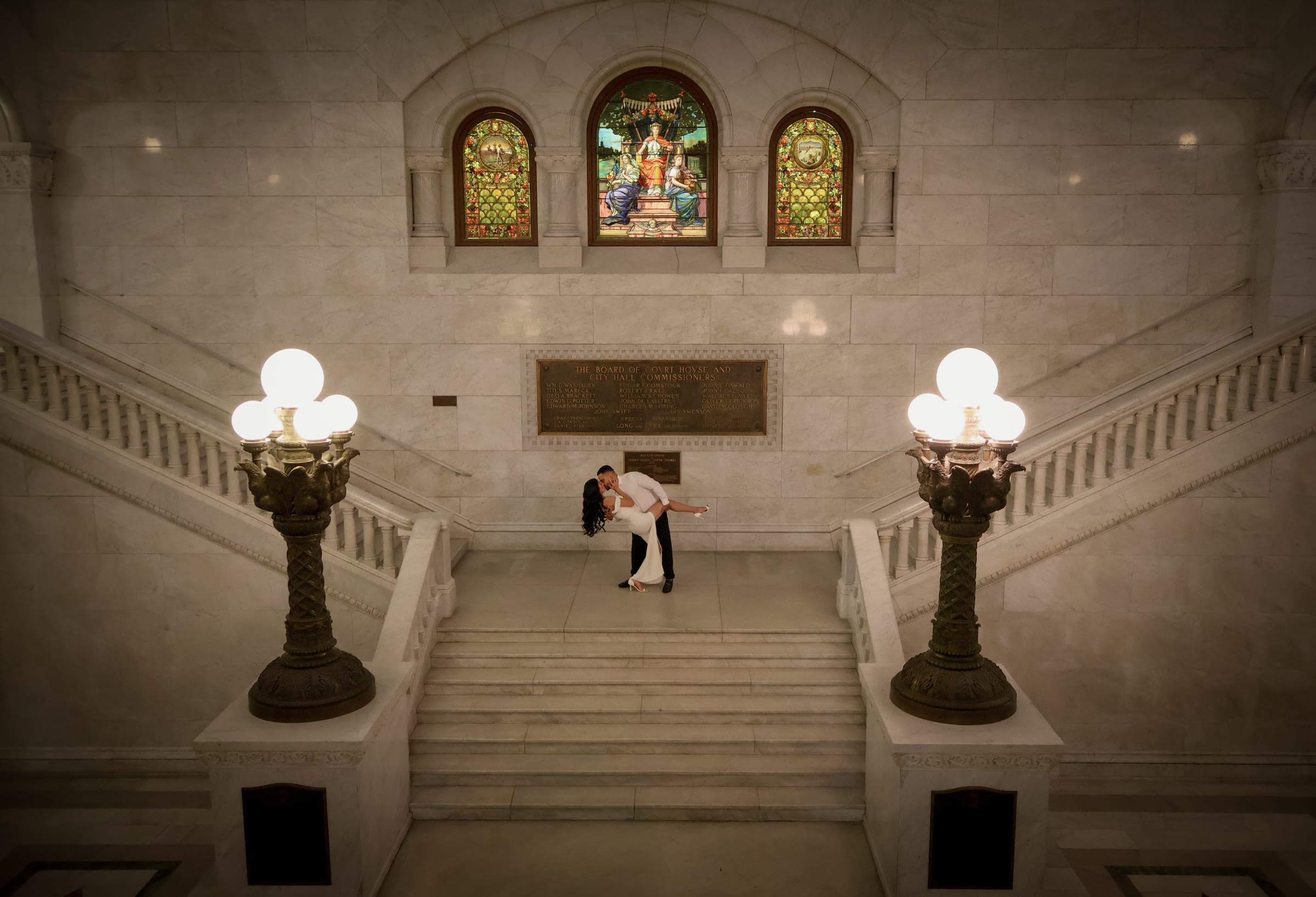 Danilo and Jotse sharing a kiss on a courthouse staircase